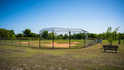 dirt baseball field surrounded by fence
