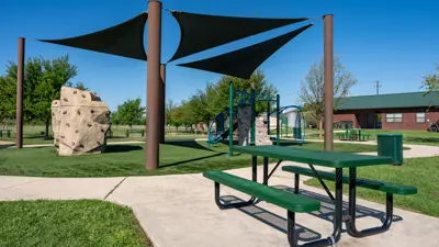 Playground under a shaded pavilion with a picnic table