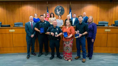 A group of people stand together in Kyle City Council Chambers to honor the Employees of the Quarter. 