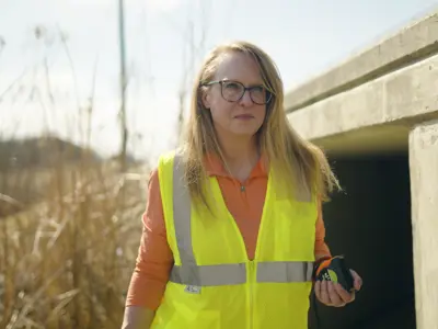 Stormwater Program Manager Kathy Roecker wears a yellow vest while working in the field. 