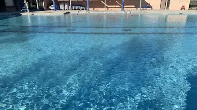 A picture of the James Adkins Pool in Kyle, Texas as the water ripples with no one in it. 