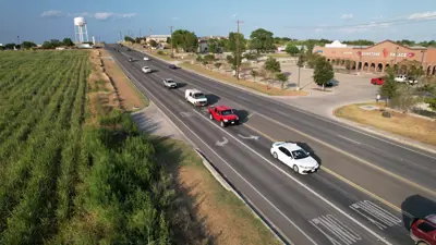 Several cars approach a stop light on a bright, sunny day in Kyle, Texas. 