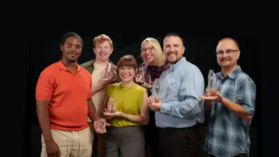 The City of Kyle Communications staff stands together holding 7 Texas Association of Municipal Information Officers awards. 