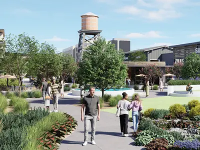 A rendering of the Kyle Park development being built along I-35 in Kyle, Texas between Windy Hill Road and Bebee Road. The rendering has a man in the foreground walking on a sidewalk with several other people around him, green space, and shops with no real names lined in the background. 