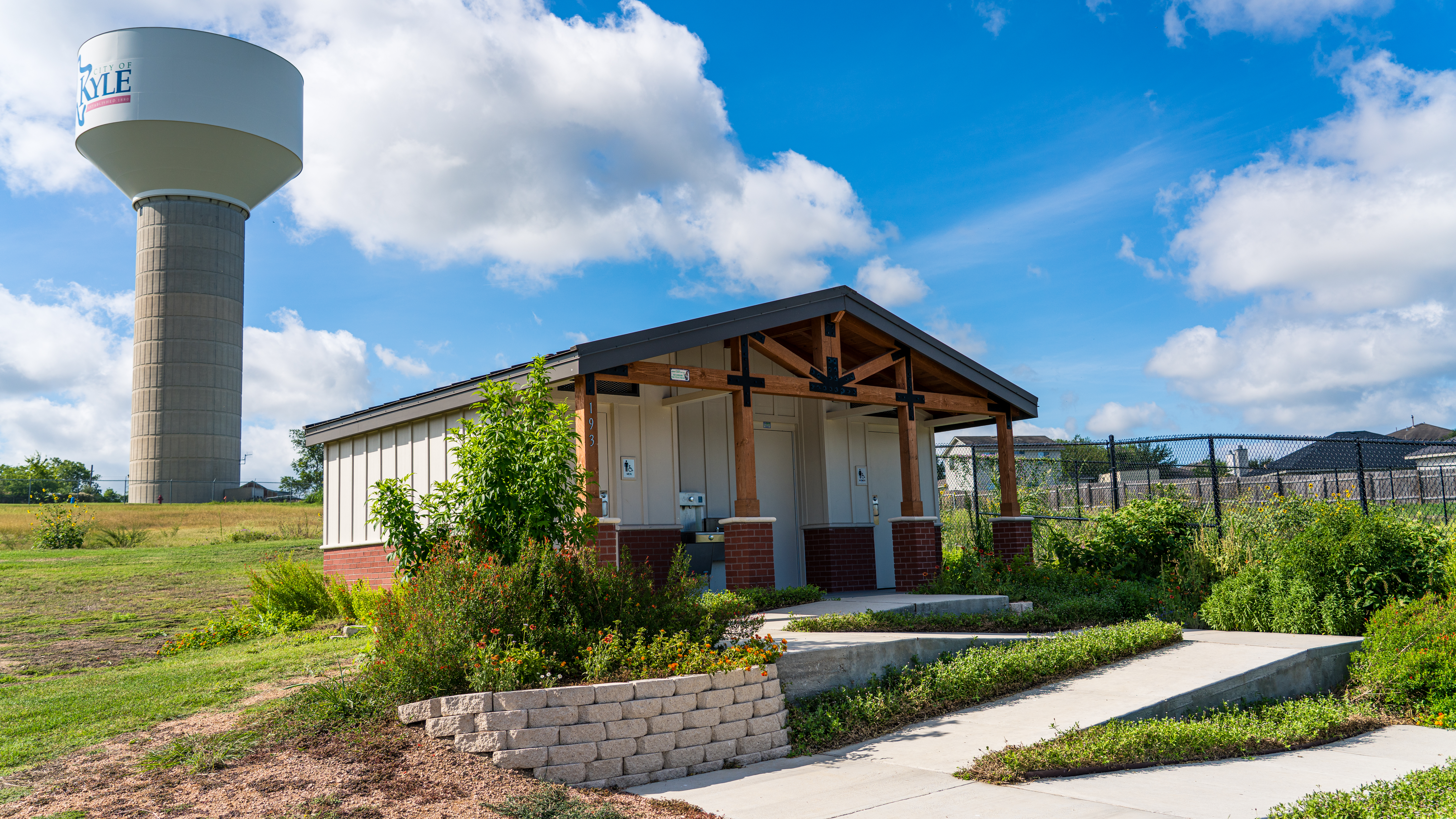 a community garden with a water tower in the background