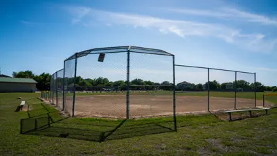 fenced in dirt baseball field